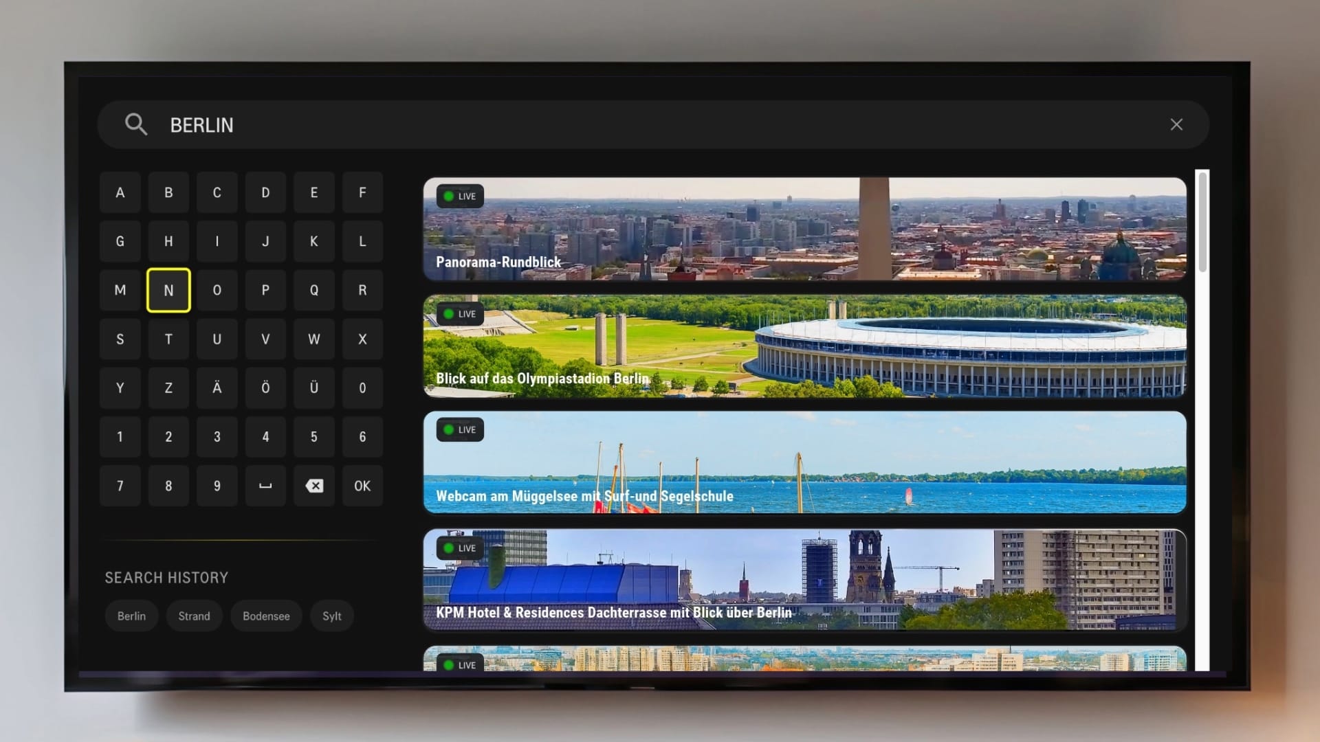 TV-Gerät mit geöffneter Suchfunktion der livespotting Fire TV App und mehreren Live Webcam Ergebnissen